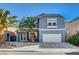 Two-story house with gray exterior, stone driveway, and palm trees at 6336 Fence Post St, Las Vegas, NV 89148