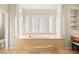Elegant bathroom with freestanding tub, marble flooring, and large windows at 7258 Sashaying Spirit Ct, Las Vegas, NV 89131