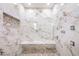 Spa-like shower with marble walls and pebble floor at 7258 Sashaying Spirit Ct, Las Vegas, NV 89131
