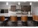 Island kitchen with granite countertops and wooden barstools at 7620 Chase Hallow St, Las Vegas, NV 89149