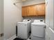 Laundry room with washer, dryer, and overhead cabinets at 7620 Chase Hallow St, Las Vegas, NV 89149