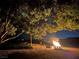 Relaxing fire pit area with seating under the trees at night at 8068 Buena Vida St, Las Vegas, NV 89166