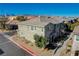 Aerial view of a two-story townhome with attached garage, landscaping, and mountain views at 8486 Insignia Ave # 101, Las Vegas, NV 89178