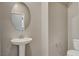 Small bathroom with pedestal sink, toilet, and oval mirror at 8486 Insignia Ave # 101, Las Vegas, NV 89178