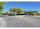 Community entrance with paved road and lush landscaping at 8486 Insignia Ave # 101, Las Vegas, NV 89178
