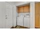 Laundry room with washer, dryer, and wood cabinets at 10079 S Riley St, Las Vegas, NV 89178