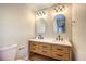 Bathroom with light wood double vanity, black matte fixtures, and arched mirrors at 104 Temple Dr, Las Vegas, NV 89107