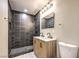 Modern bathroom with dark tile shower and a wood vanity at 104 Temple Dr, Las Vegas, NV 89107