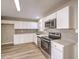 Modern kitchen featuring white shaker cabinets, stainless steel appliances, and quartz countertops at 104 Temple Dr, Las Vegas, NV 89107