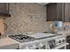 Stainless steel gas cooktop with designer backsplash at 11903 Sandstone Arch Dr, Las Vegas, NV 89138