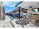 Covered outdoor kitchen with grill, bar seating, and TV at 11903 Sandstone Arch Dr, Las Vegas, NV 89138