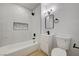 Modern bathroom with white vanity, marble tile, and a bathtub at 1208 Marion Dr, Las Vegas, NV 89110