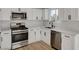 Modern kitchen with white cabinets, stainless steel appliances, and quartz countertops at 1208 Marion Dr, Las Vegas, NV 89110