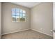 Small bedroom with large window and carpet flooring at 1608 Council Bluff Ln, North Las Vegas, NV 89031