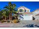 Two-story house with attached garage, landscaping, and palm trees at 1608 Council Bluff Ln, North Las Vegas, NV 89031