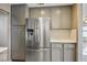 Stainless steel refrigerator in kitchen with gray cabinets at 1608 Council Bluff Ln, North Las Vegas, NV 89031