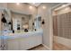 Bathroom featuring a long dual sink vanity with decorative lights, and a shower/tub at 1610 Dire Wolf Avenue, North Las Vegas, NV 89084