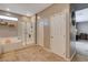 Bright bathroom featuring a tiled floor, dual-entry shower, soaking tub and large decorative wall mirror at 1610 Dire Wolf Avenue, North Las Vegas, NV 89084