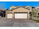 Two-story house with a beige facade, two-car garage, and landscaped yard at 1610 Dire Wolf Avenue, North Las Vegas, NV 89084