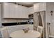 Bright kitchen with stainless steel appliances, white cabinets, black countertops, and a round white table at 1610 Dire Wolf Avenue, North Las Vegas, NV 89084