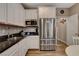 Well-lit kitchen features stainless steel refrigerator, white cabinets, and dark countertops at 1610 Dire Wolf Avenue, North Las Vegas, NV 89084