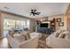 Bright living room with large windows, plush sofas, and entertainment center, perfect for relaxation and entertainment at 1610 Dire Wolf Avenue, North Las Vegas, NV 89084