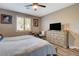 Bright main bedroom with desk, natural light, ceiling fan, and wood-look flooring at 1610 Dire Wolf Avenue, North Las Vegas, NV 89084