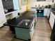 Kitchen with large black countertop island and teal cabinets at 1695 Westwind Rd, Las Vegas, NV 89146