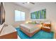 Bedroom with wood bed frame, teal rug, and window at 210 Bella Noche St, Las Vegas, NV 89138