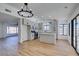 Open concept kitchen with island, light wood floors, and modern chandelier at 2157 Wagonwheel Ave, Las Vegas, NV 89119