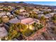 Backyard view of a beautiful house with mature trees, manicured lawn and mountain view at 3 Pine Hollow Dr, Henderson, NV 89052