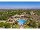 Aerial view of a community pool and clubhouse surrounded by lush landscaping, homes and city skyline at 3 Pine Hollow Dr, Henderson, NV 89052