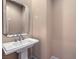 Powder room with a pedestal sink and modern mirror at 3 Pine Hollow Dr, Henderson, NV 89052