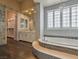 Elegant bathroom featuring a soaking tub with mosaic detail, white cabinets, tile walls and closet at 3 Pine Hollow Dr, Henderson, NV 89052