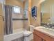 Well-lit bathroom featuring a shower-tub combo, blue accent shelving, and modern fixtures at 3 Pine Hollow Dr, Henderson, NV 89052