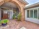 Inviting entrance with stone archway, decorative door and stone-paved area with lush landscaping at 3 Pine Hollow Dr, Henderson, NV 89052