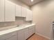 Bright laundry room features white cabinetry and a sink, offering convenience and functionality at 3 Pine Hollow Dr, Henderson, NV 89052