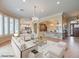Spacious living room featuring a chandelier, large windows, and an open floor plan into the kitchen at 3 Pine Hollow Dr, Henderson, NV 89052