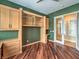 Stylish home office with hardwood floors, custom cabinetry and shelving; view to hallway at 3 Pine Hollow Dr, Henderson, NV 89052