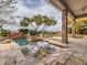 Inviting outdoor pool and spa with stone accents, lush landscaping, and a covered patio for relaxation at 3 Pine Hollow Dr, Henderson, NV 89052