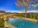 Beautiful pool with rock waterfall feature and lush landscaping creates a backyard oasis for relaxation at 3 Pine Hollow Dr, Henderson, NV 89052