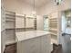 Large walk-in closet featuring custom shelving, drawers, and a center island with marble top at 3 Pine Hollow Dr, Henderson, NV 89052