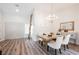 Elegant dining room with a rustic wooden table, white chairs, and a chandelier at 3105 Birdwood Dr, Las Vegas, NV 89134