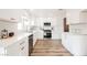 Modern white kitchen with stainless steel appliances and quartz countertops at 3105 Birdwood Dr, Las Vegas, NV 89134