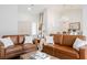 Bright living room featuring brown leather couches, a coffee table, and a view into the dining area at 3105 Birdwood Dr, Las Vegas, NV 89134