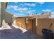 Fenced backyard with paved patio space, a wooden gate, and minimal desert landscaping at 3802 Terrazzo Ave, Las Vegas, NV 89115