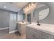 Bathroom featuring double vanities with modern fixtures, round mirrors, and wood-look flooring at 3802 Terrazzo Ave, Las Vegas, NV 89115