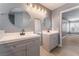 Bathroom featuring double vanities with modern fixtures, round mirrors, and wood-look flooring at 3802 Terrazzo Ave, Las Vegas, NV 89115