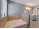 Bathroom featuring a soaking tub, double vanities with modern fixtures, and wood-look flooring at 3802 Terrazzo Ave, Las Vegas, NV 89115