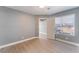 Spacious bedroom with grey walls, wood-look floors, and a view of the backyard at 3802 Terrazzo Ave, Las Vegas, NV 89115